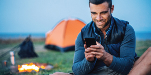 Man texting at campsite